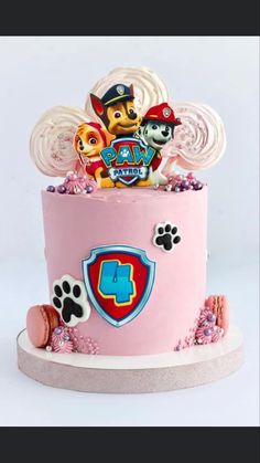 a pink cake with paw patrol decorations on top