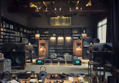 a room filled with lots of speakers and bookshelves next to a table in front of a window