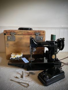 an old sewing machine sitting on top of a table next to a piece of luggage