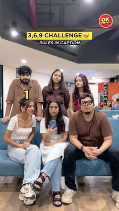 a group of people sitting on top of a blue couch