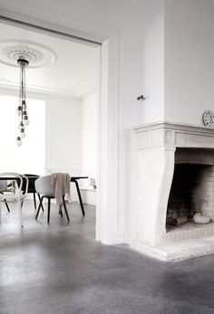 a white room with a fireplace and chairs