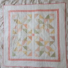 a quilted table topper with an arrow design on the front and back side