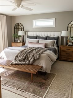 a bedroom with a bed, dressers and mirror in it's center area