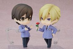 two anime figurines are standing next to each other holding a rose in their hands