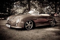 an old car is parked in the grass