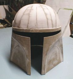 a boba fett helmet sitting on top of a table