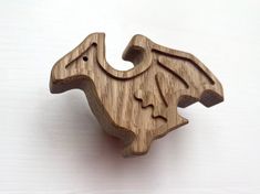 a wooden brooch with an image of a bird on it's back side