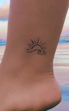 a small sun and wave tattoo on the ankle