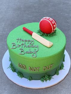 a green birthday cake with a baseball bat and ball on top that says happy birthday baby, do not out