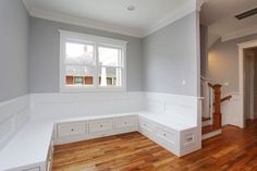 an empty room with hard wood flooring and white painted walls on either side of the door