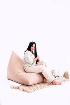 a woman sitting on top of a bean bag chair