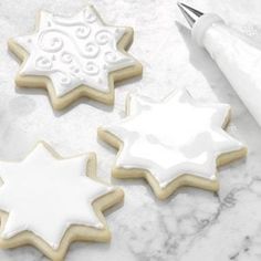 three decorated sugar cookies sitting on top of a table next to a marker and pen