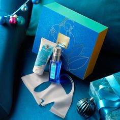 a blue couch with christmas decorations and personal care items on it next to a gift box