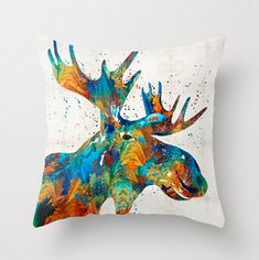 a colorful moose pillow on a white wall