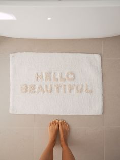 a person standing in front of a towel that says hello beautiful