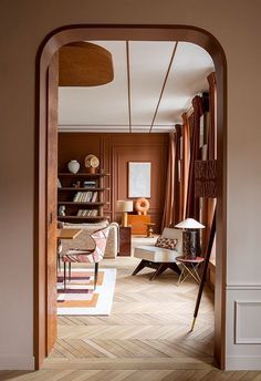 an open doorway leading to a living room with furniture and bookshelves on the walls