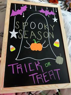 a chalk board with writing on it that says spooky season trick or treat