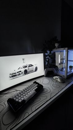 two computer monitors sitting on top of a desk next to a keyboard and monitor screen