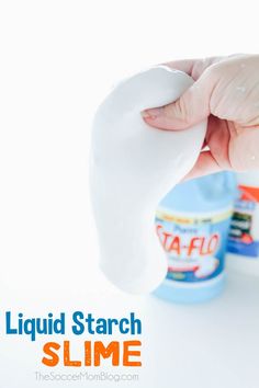 a hand holding a liquid starch in front of a bottle with the lid open