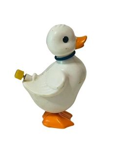 a white duck with an orange beak and blue collar sitting on top of a yellow base