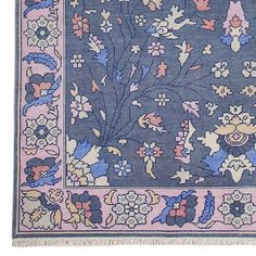 a blue and pink rug with flowers on it's border, in the shape of a tree