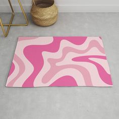 a pink and white rug on the floor next to a basket