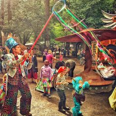 a group of people standing around each other in front of a tiki pole with decorations on it