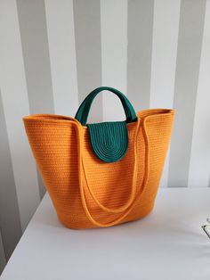 an orange and green purse sitting on top of a table