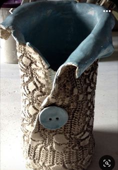 a ceramic vase with an animal face on it's side and the bottom part of its body