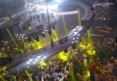 a large group of people standing around in a room filled with lights and disco balls