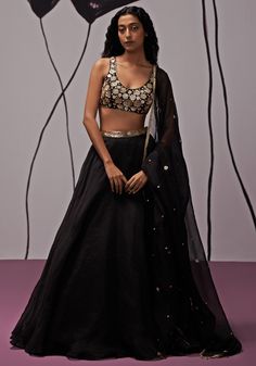 Featuring a stunning black lehenga crafted from silk organza, accented with a embroidered belt for added allure. Paired elegantly with a crepe blouse featuring intricate gold embroidered floral motifs and topped off with an embroidered dupatta with tassels. Ideal choice for adding a luxurious touch to Sangeet outfit. Composition : Blouse - Crepe, Lehenga -Silk Organza, Dupatta - Silk Organza Care: Dry Clean Only and Vacuum Storage This product can be customized for sleeves, length of blouse and neckline Delivery : 4-6 weeks as the product is hand crafted. Check Size Guide or choose MySize for free customisation (All Sizes above XL can be made at 15% additional cost) For more information and sizes please contact fabiliciousfashion@gmail.com or visit our Copenhagen studio. About the Designer Black Lengha Outfit, Lehenga Shoot, Black Sequin Lehenga, Black And Gold Lehenga, Crepe Lehenga, Lehenga Black, Lengha Dress, Black Sequin Blouse, Lehenga Top