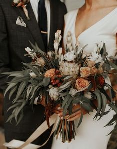 a bride and groom are holding their bouquets