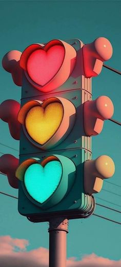 a traffic light with two hearts on it's red and green lights, against a blue sky