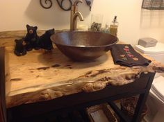 a wooden table with a bowl on it and two figurines next to it