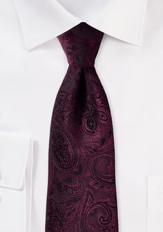 This stunning paisley tie in a rich claret crimson color is the ideal accessory for a traditional wedding like the one you're planning. We use a very small amount of black thread to define the paisley pattern that we weave into the fabric before we pull it tight. Because of this process, the tie has a delicate feel, and its surface shimmers beautifully in the light. This tie looks great when worn with dark suits and tuxedos, as well as some lighter shades of grey clothing. The safest option is t Elegant Purple Neckwear For Black Tie Event, Elegant Business Suit And Tie Accessories With Paisley Print, Elegant Paisley Print Neckwear For Business, Elegant Red Adjustable Neckwear, Elegant Adjustable Red Neckwear, Elegant Formal Ties With Paisley Print, Elegant Semi-formal Ties With Paisley Print, Elegant Semi-formal Neckwear With Paisley Print, Elegant Semi-formal Paisley Print Ties