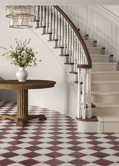 a white vase with flowers sitting on top of a table next to a stair case