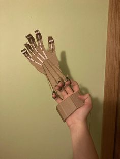 a person holding up several pieces of cardboard with scissors in it's palm and fingers