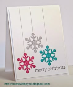 a christmas card with two snowflakes hanging from it's sides and the words merry christmas