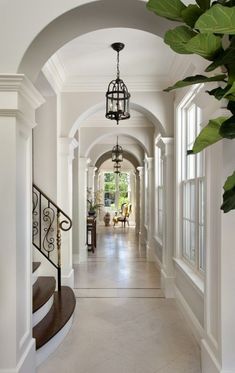 the hallway is lined with white walls and arched doorways