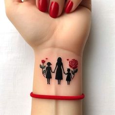 a woman's wrist tattoo with an image of a mother and child holding hands