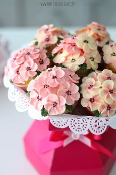 cupcakes decorated with pink and white flowers in a vase