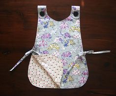 a bib with two pockets on it and one pocket in the middle, sitting on top of a wooden table