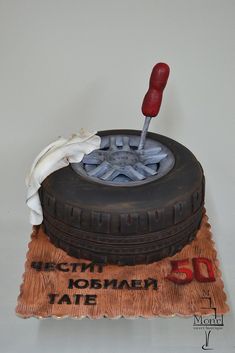 a cake made to look like a tire with a white cloth on top and a red toothpick sticking out of it