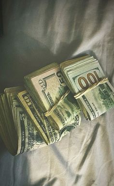 a pile of money sitting on top of a bed