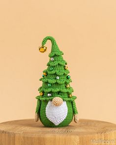 a small green christmas tree sitting on top of a wooden table