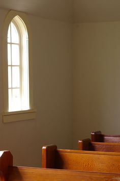 an empty church pews in front of a window