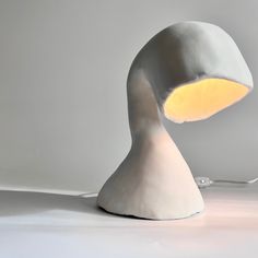 a white table lamp with a yellow light on it