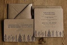 the wedding stationery is made from brown paper and has pine trees on it, along with an envelope