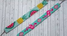 two beaded bracelets with flowers and hearts on them sitting on a wooden surface