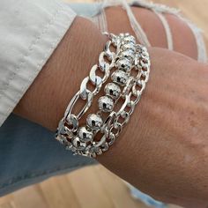 Absolutely gorgious, bright silver color stylish and elegant layered mixt chain bracelet that look perfect as well with chic or casual outfits.  ADD approximately 3/4 - 1 1/4 inches to your wrist size TO SELECT A SIZE  The 4 chains of the bracelet are united to a linking ring. On picture, 6.5 inches wrist showing the adjustable 7.25 to 8 inches bracelet, attached at 7.25 inches.  THE 8MM BALL CHAIN MAY LOOK SMALLER ON A LARGER WRIST MATERIALS * CHAINS: Quality SILVER COLOR plated stainless steel Chunky Silver Jewellery, Gift Bracelet, Multi Strand Bracelet, Linking Rings, Figaro Chains, Figaro Chain, Bracelet For Women, Ball Chain, Multi Strand